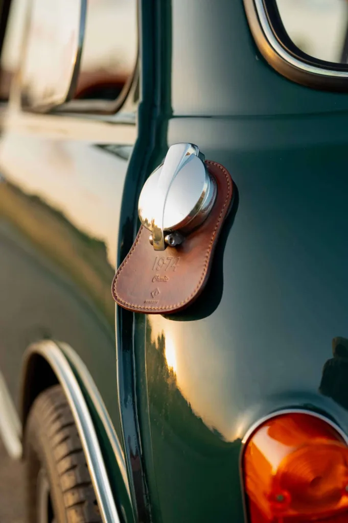 Koncept Studios brown leather fuel bib with custom engraving installed on a green classic Mini