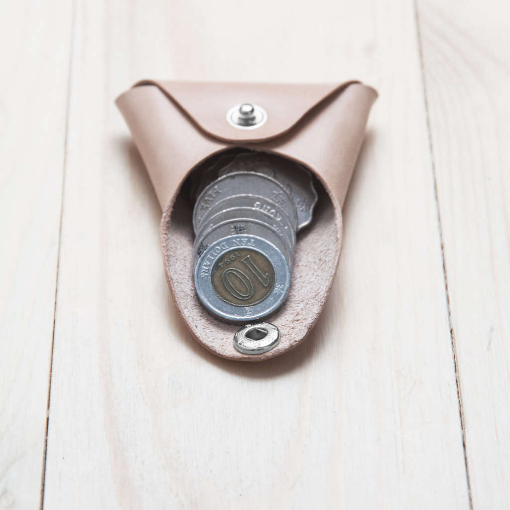 Natural leather coin purse case by Koncept Studios with snap button closure holding coins